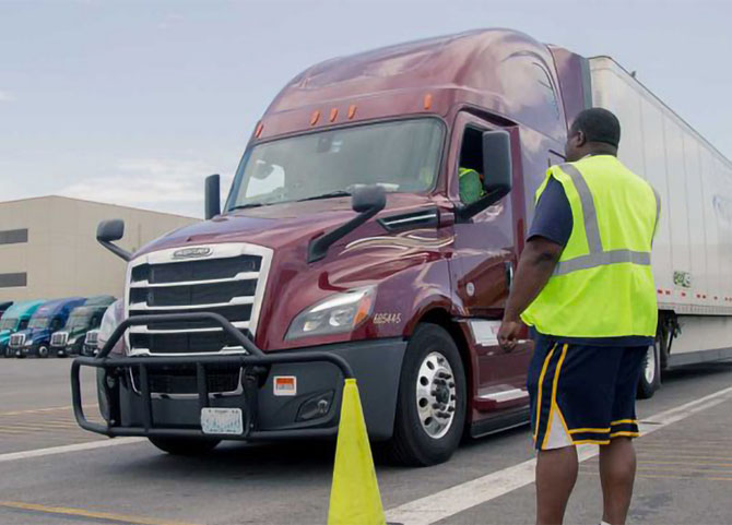 Man with yellow vest next to a truck